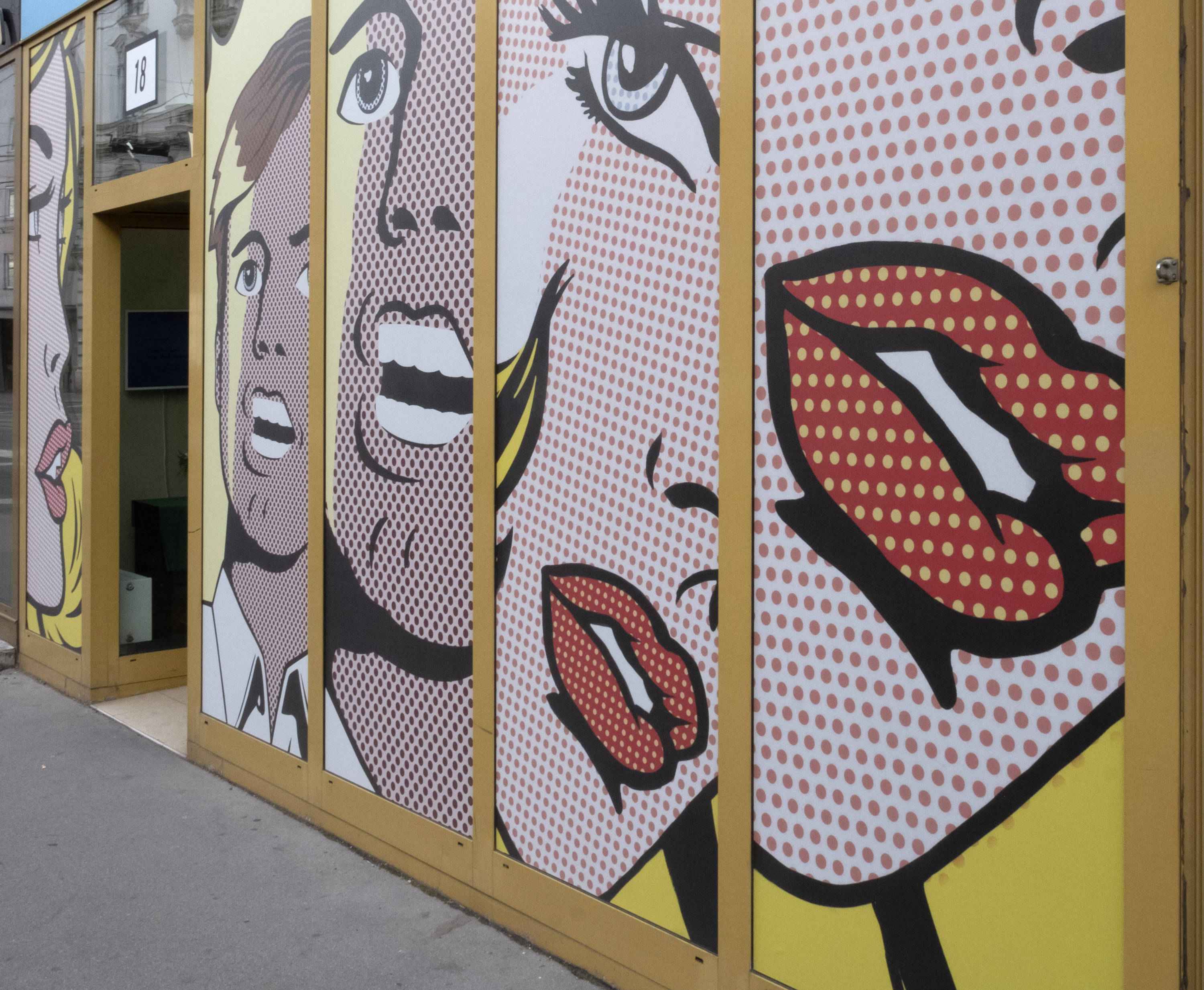 Glass front in the street. Glass covered from top to bottom with illustrations: Heads of talking and laughing persons.