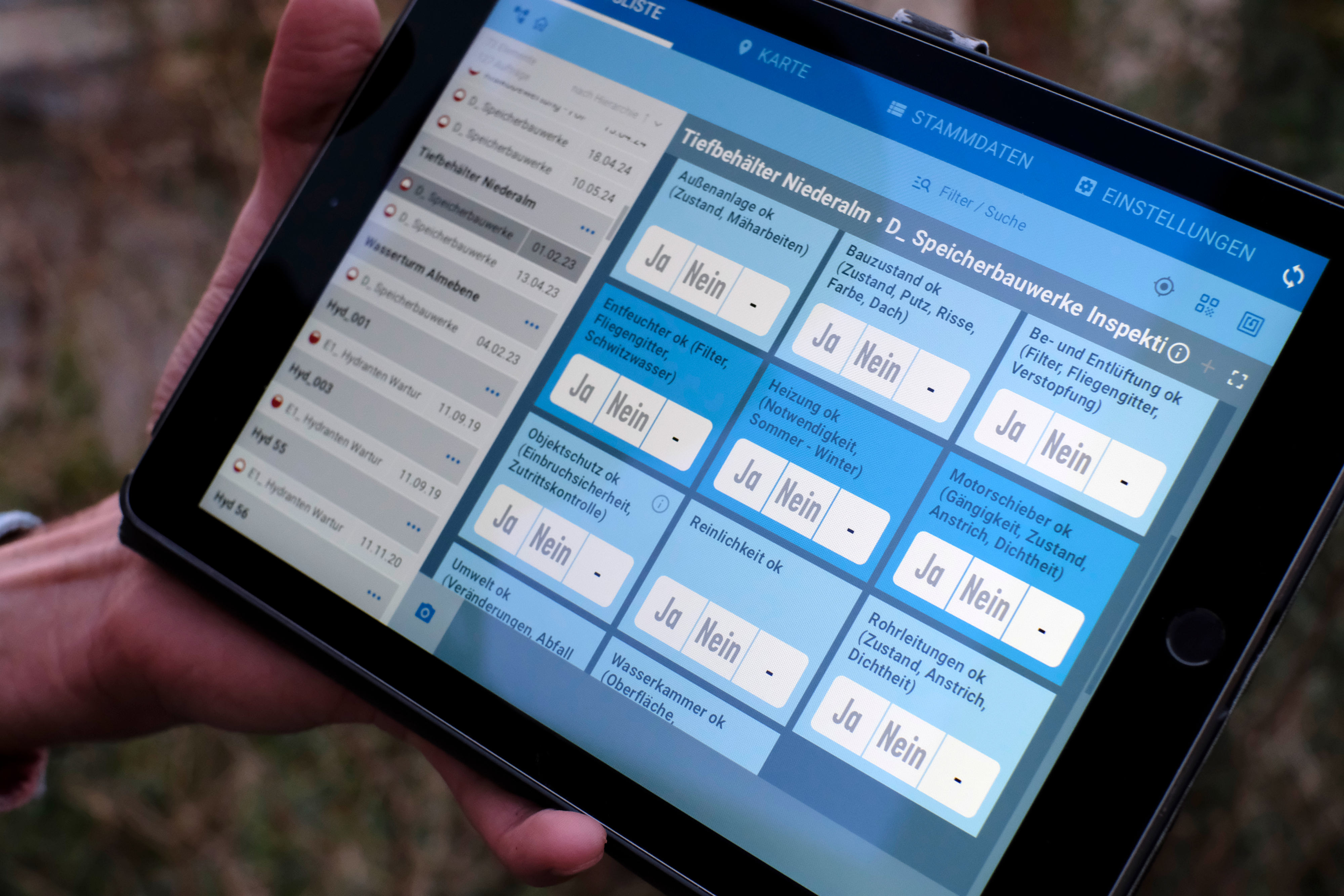 Hand holding tablet computer. Screen displays layout of list beside grid of tiles.