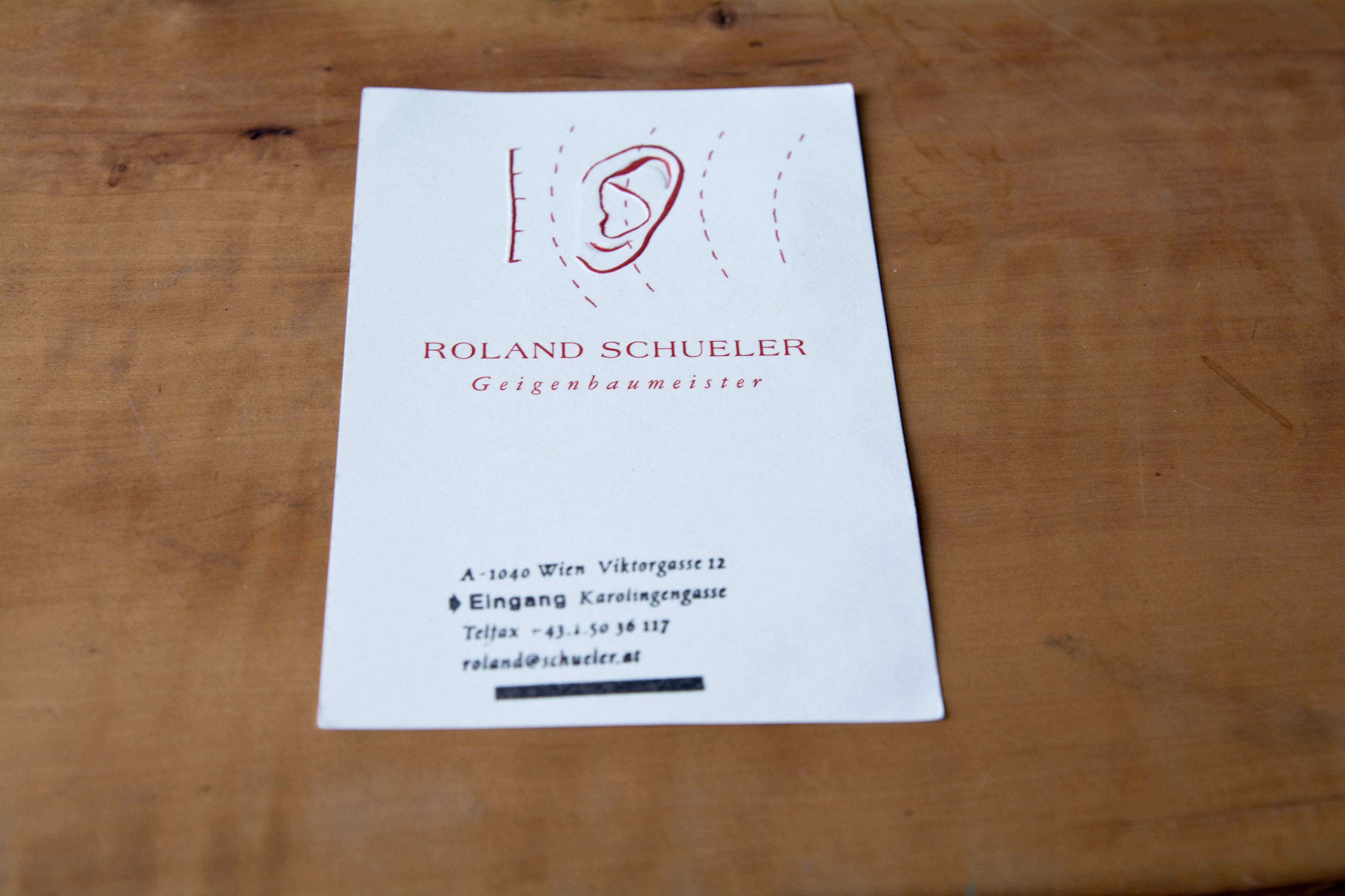 Business card violin maker. Partly embossed logo.