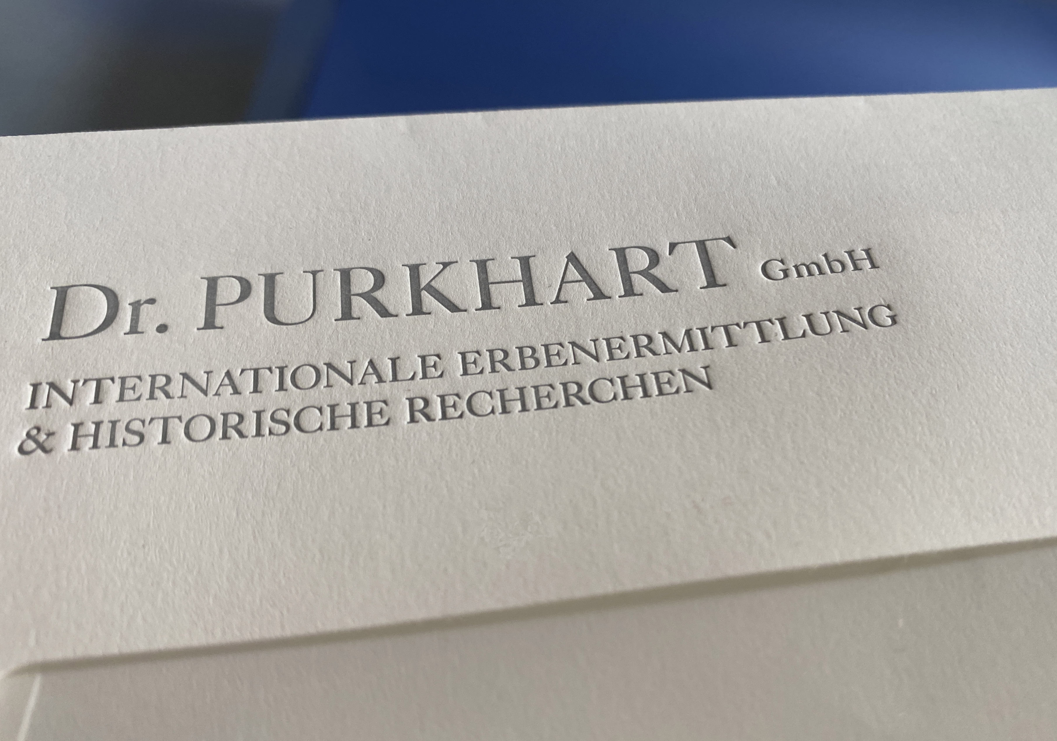 Close up of envelope with embossed logotype.
