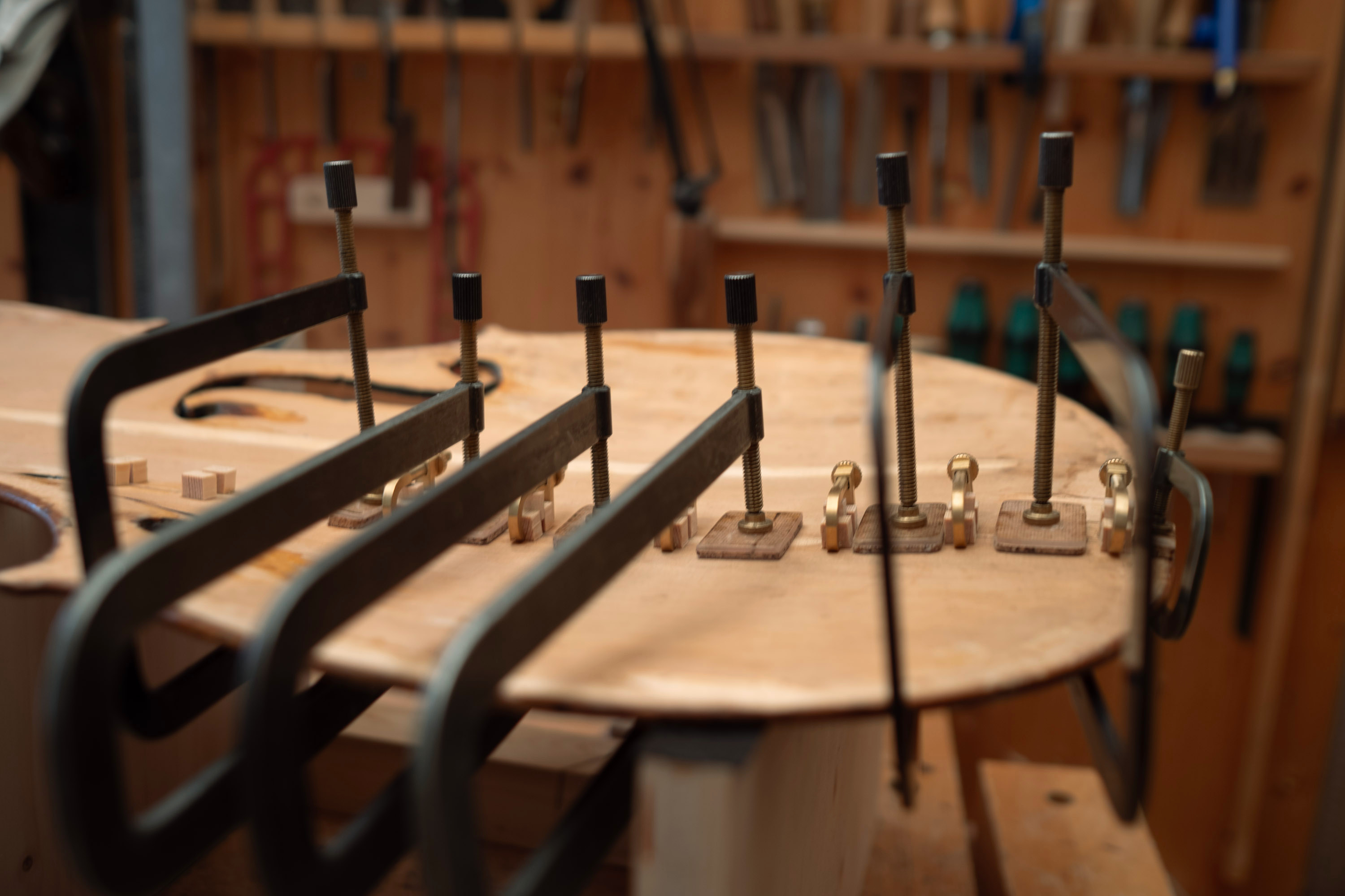 Inside violin maker's workshop. Close-up of violin top plate in repair.