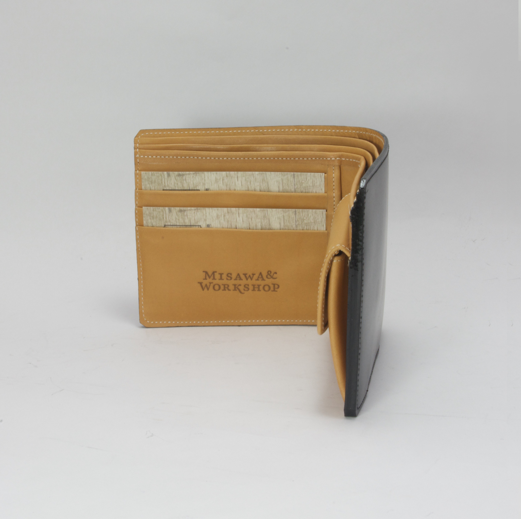 Opened leather wallet. Brand stamped logo on inside.