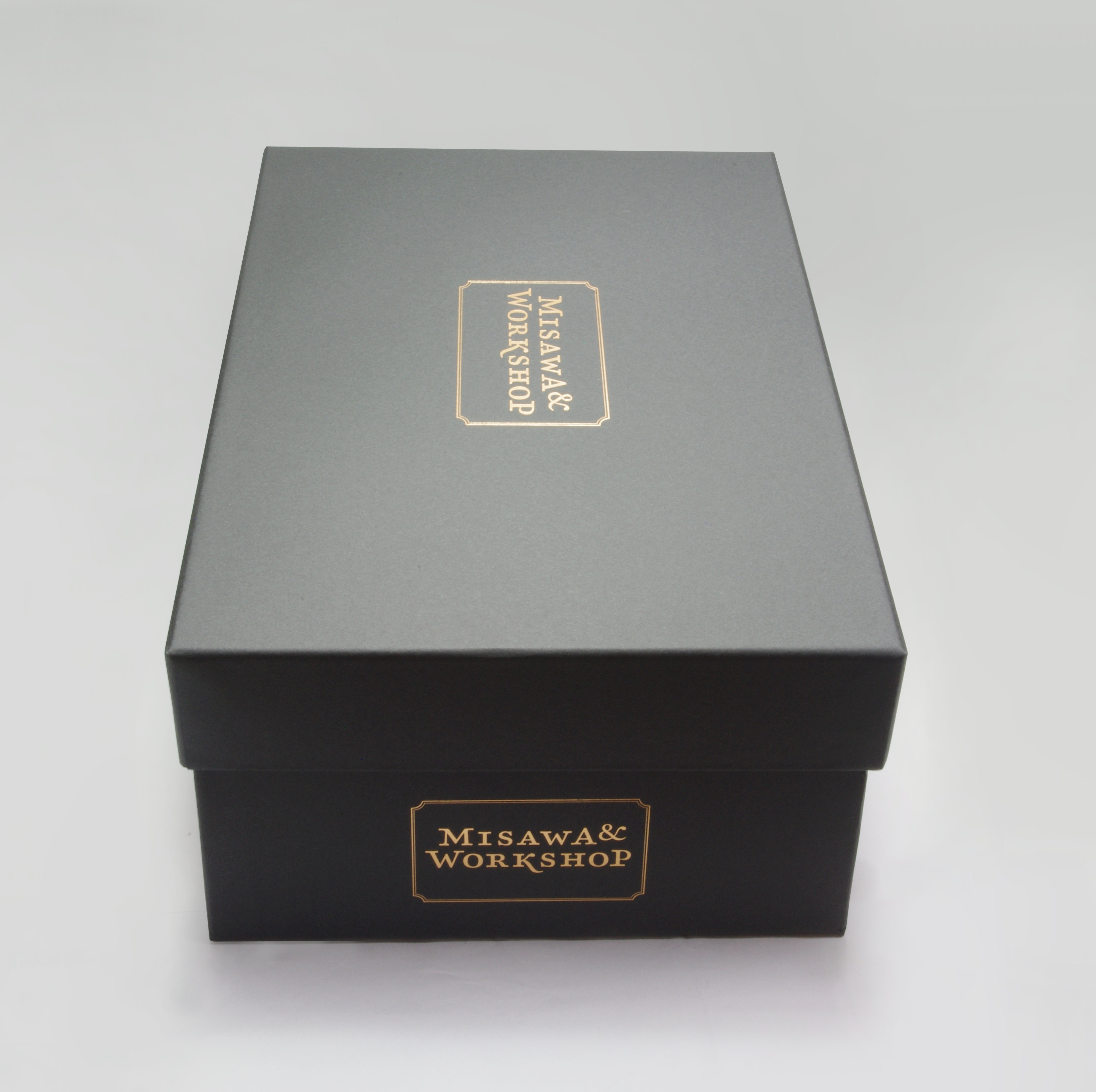 Black shoe box. Logo printed in gold at side and on lid.