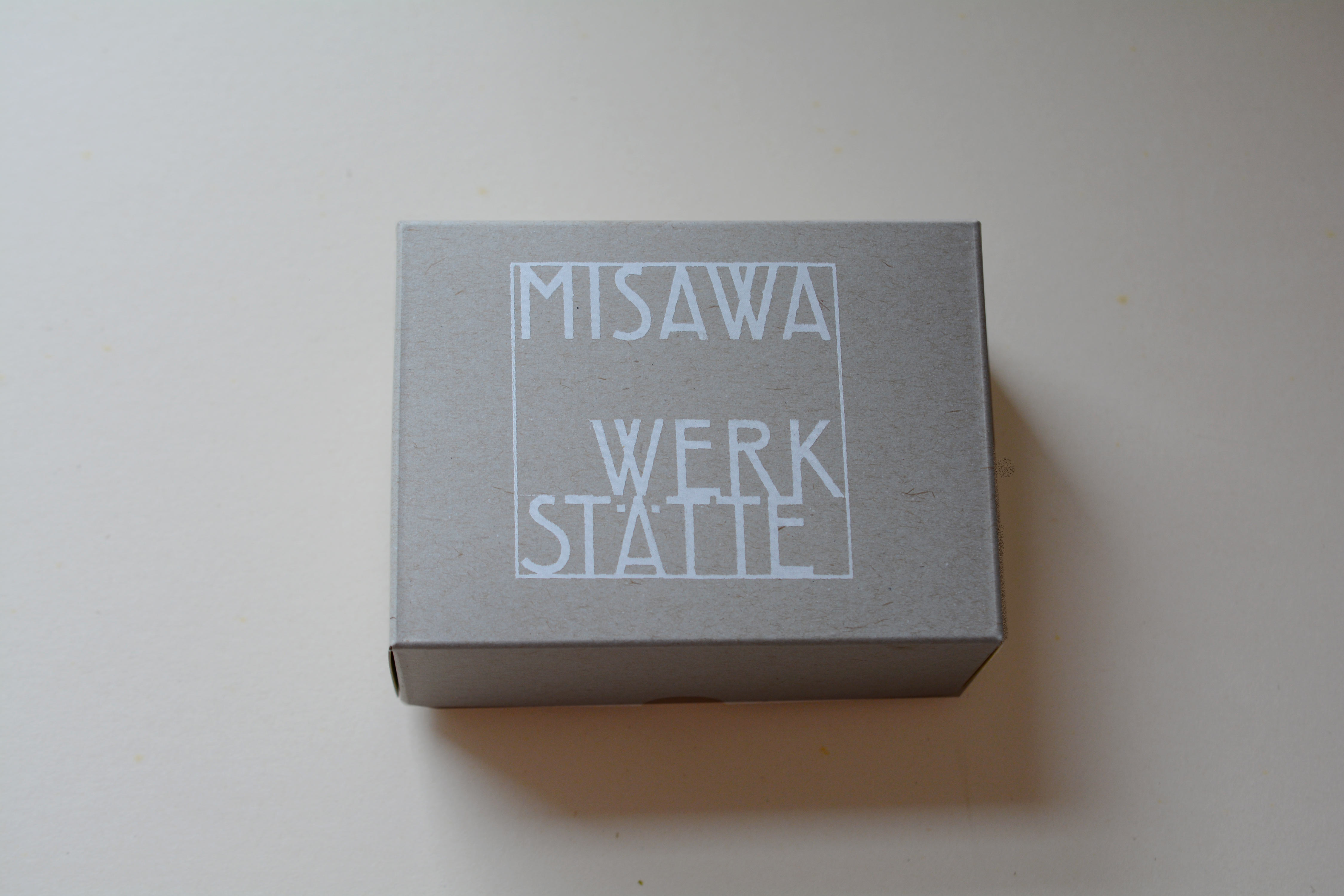 Grey carton box. Logo printed on in white on lid.