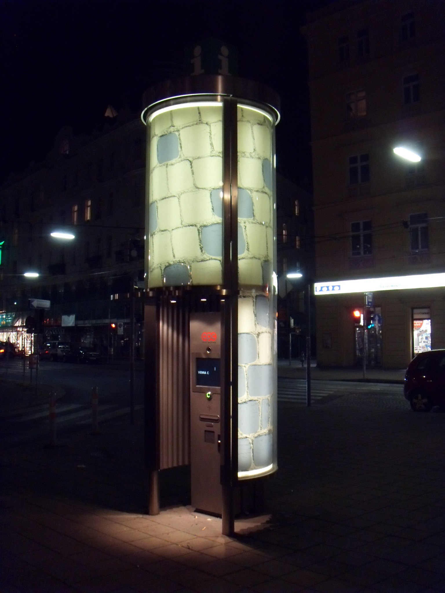Nighttime. Back side of advertising glass-pillar.