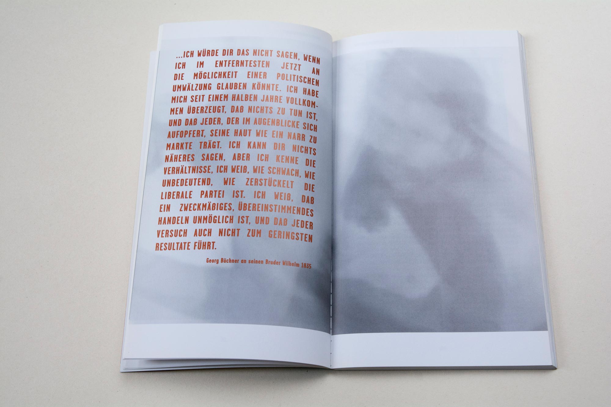 Double Page. Light b/w in the background. Block of bold text overlayed on left page. White space at bottom.