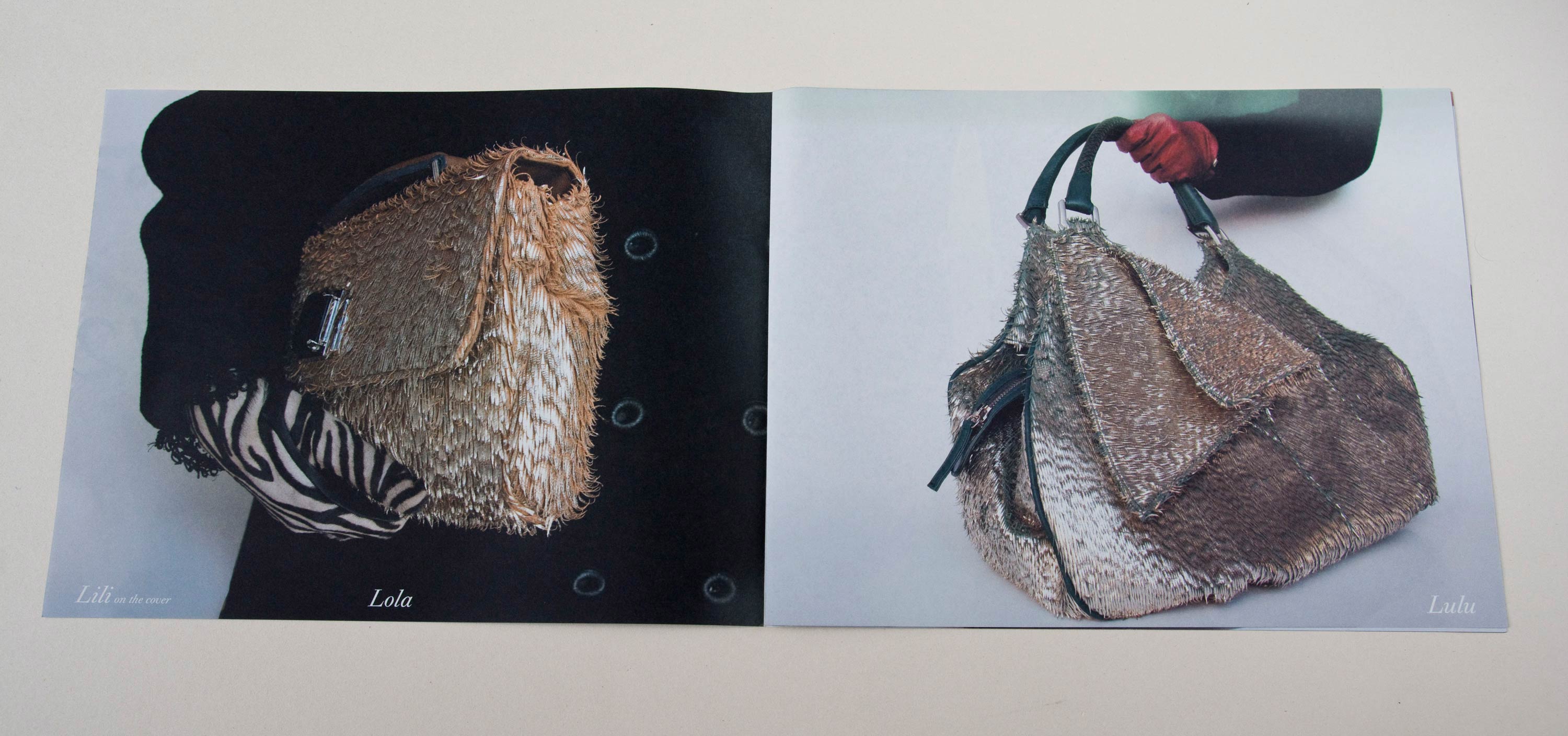Double page with full-page photos. Script font overlayed at bottom. Left: Close-up of arm holding handbag. Right: Close-up of hand holding handbag.