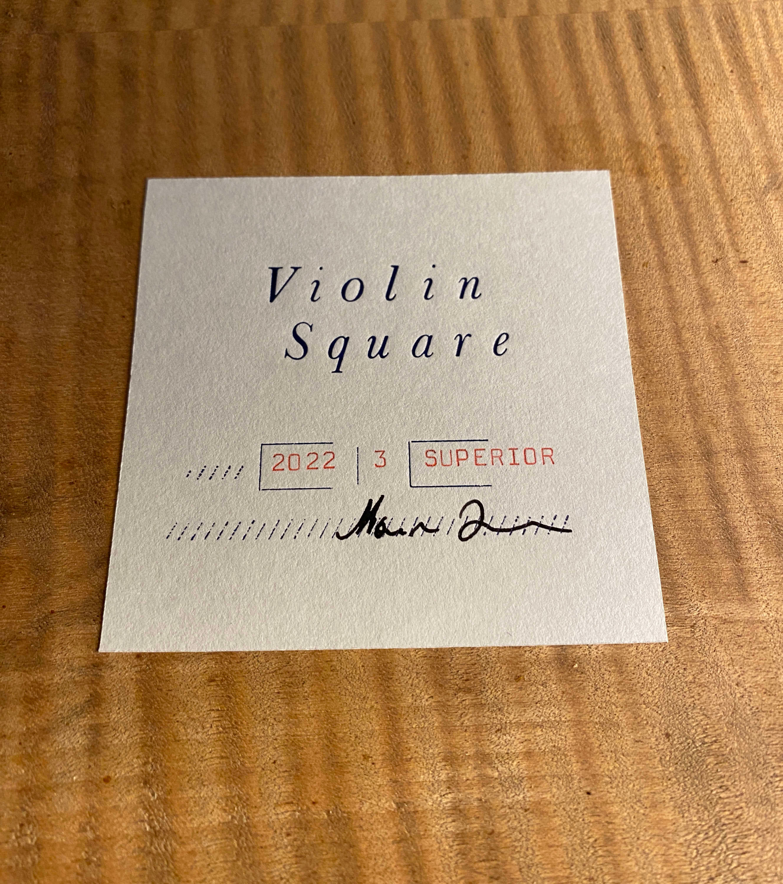 Paper label inside body of instrument. Logo on top. Classifications and signature underneath.